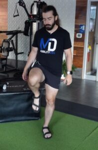 Dr. John skippin off of one leg bringing the other knee to hip height as an active range of motion